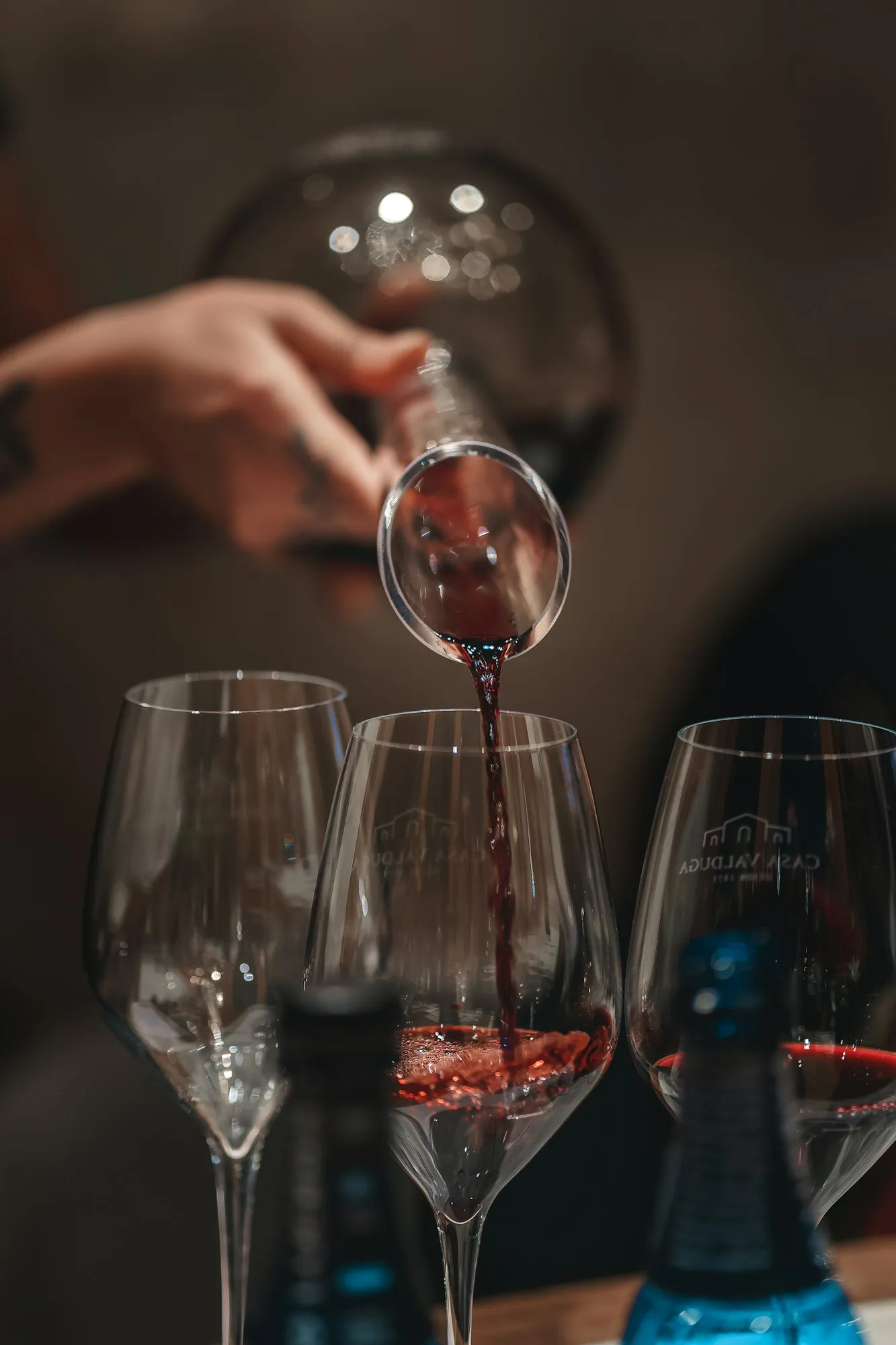 Vino rosso versato da un decanter in tre calici